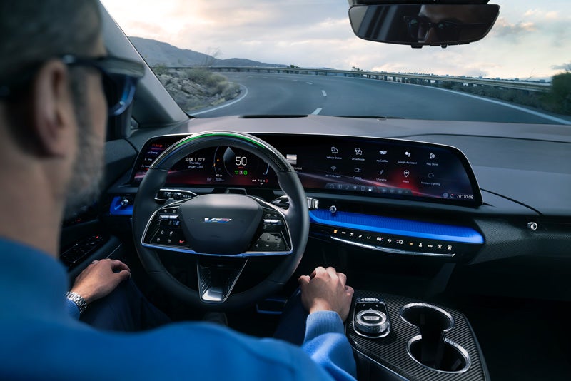 Front View of the 2026 OPTIQ-V Driving Through the Dusk Utilizing its Headlights | Ed Morse Cadillac Delray Beach FL in Delray Beach FL