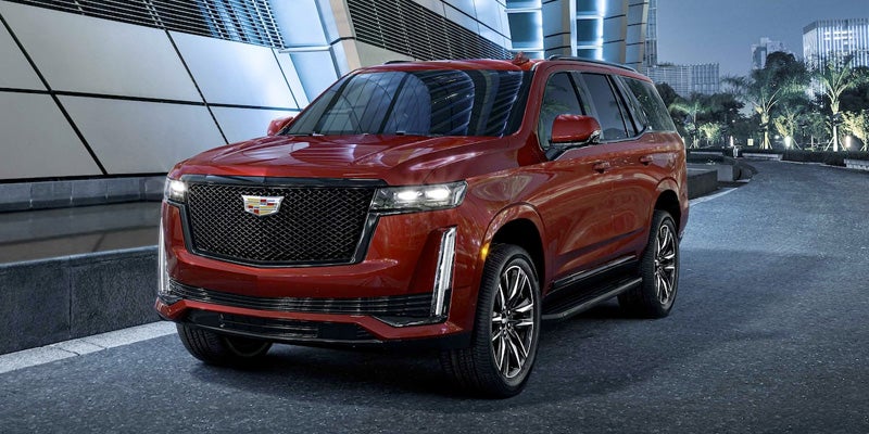 red Cadillac Escalade with headlights on